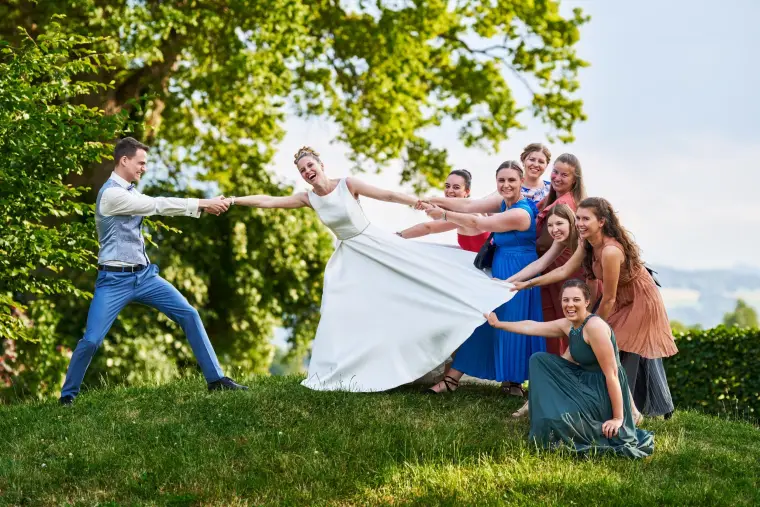 Hochzeitsreportage: Gäste ziehen an Brautkleid