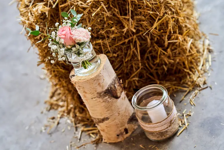 Hochzeitsreportage: Blumen und Kerze am Heu