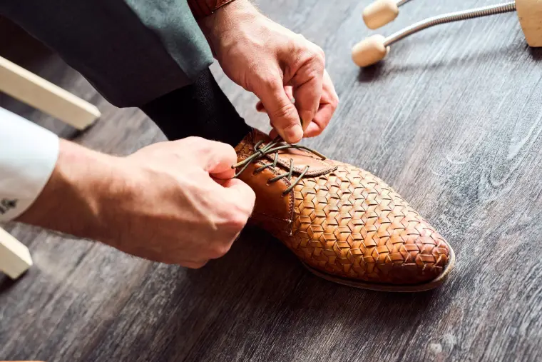 Hochzeitsreportage: Bräutigam bindet Lederschuh