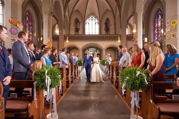 Hochzeitsreportage: Brautpaar beim Einzug in Kirche
